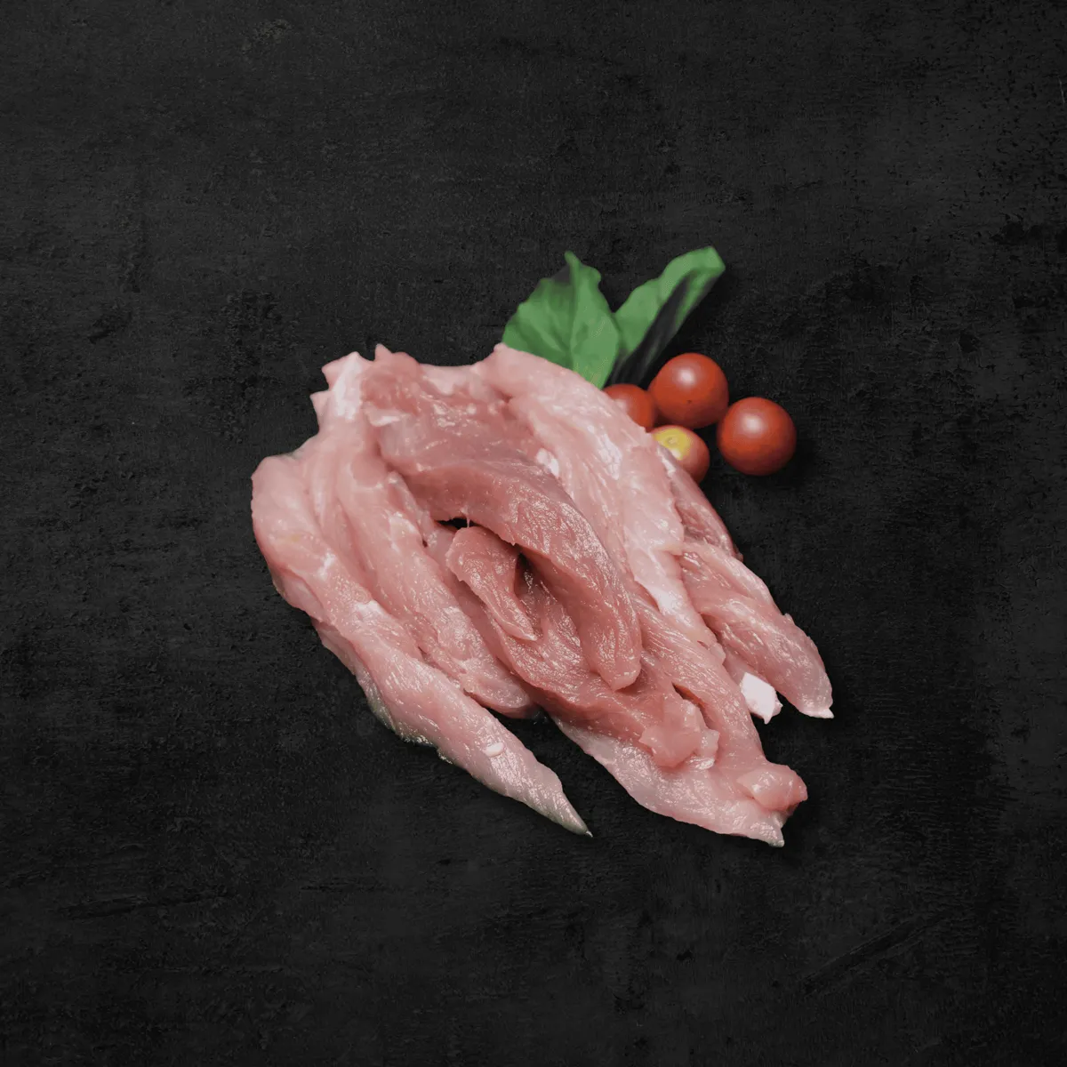 Fajitas de cerdo en tiras sobre fondo oscuro