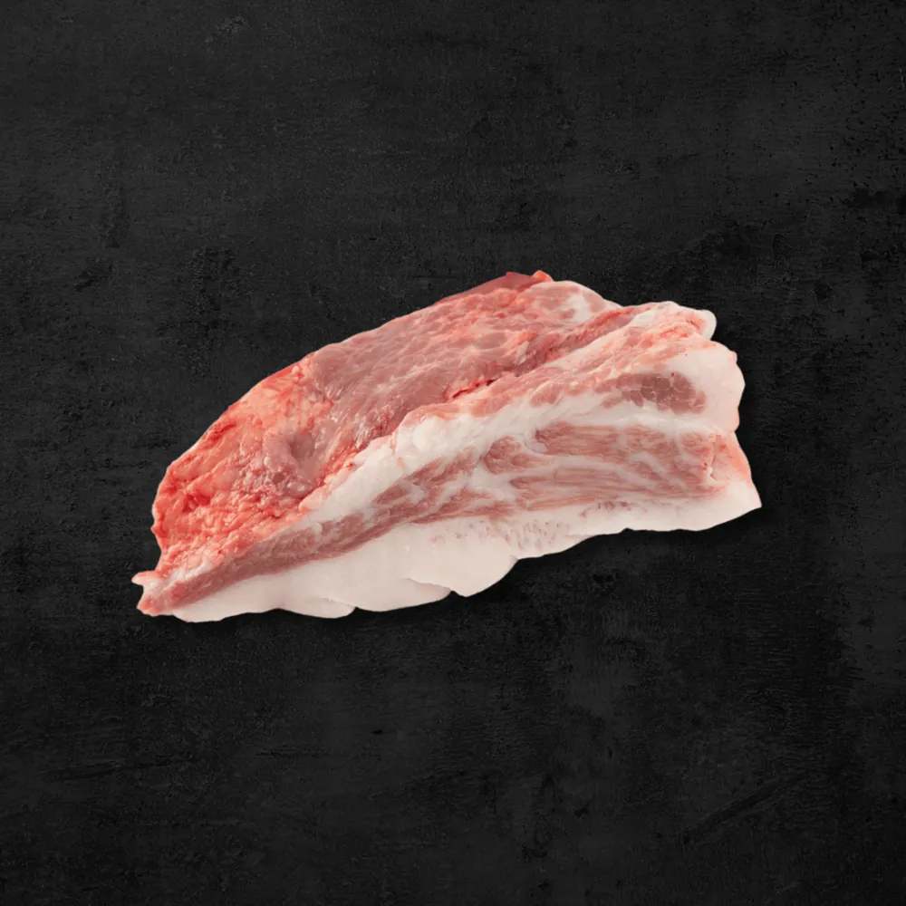 Tocino de papada de cerdo sobre fondo oscuro